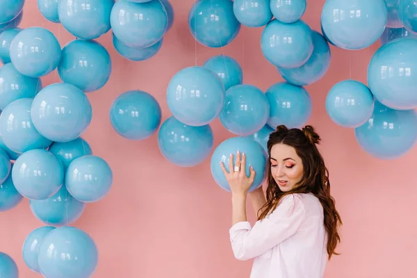 Menina em uma sala rosa com bolas azuis — Fotografia de Stock