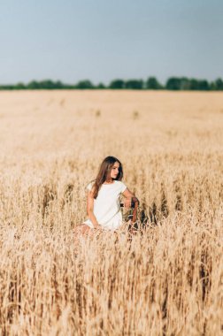 Kız bir buğday alanında bir yaz akşamı yürür.