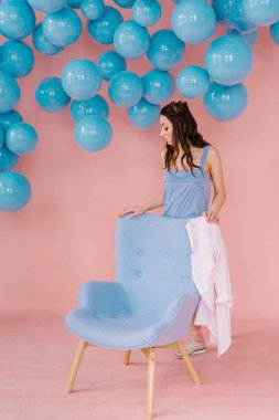 Mavi topları ile pembe bir odada mavi elbiseli güzel kız bir