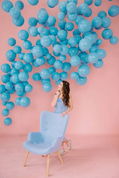 Menina em vestido azul em uma sala rosa — Fotografia de Stock