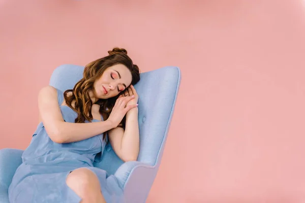 Uma menina com cabelos longos e fluindo um vestido azul, adormeceu em um — Fotografia de Stock