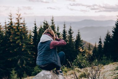 Kız bir rock ve fotoğrafları Dağları üzerinde oturur