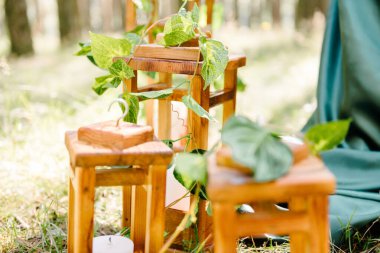 Ormanın zemininde yeşil çimlerin olduğu arka planda yakın plan bir düğün dekorunun ayrıntıları.
