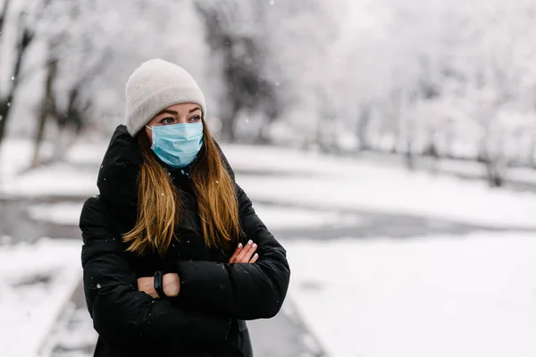 滅菌医療用マスクの少女は 雨の多い雪の日に屋外でインフルエンザウイルスから保護します — ストック写真