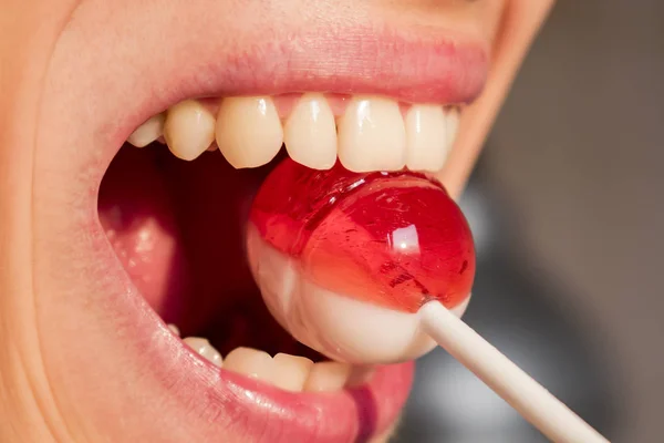 Der Junge Mann Hält Ein Bonbon Auf Einem Stock Den — Stockfoto