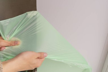 İşçi plastik yokuştan koruyucu bandı çıkarır