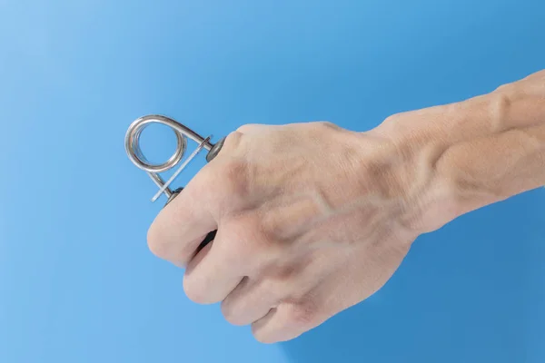 A mão de um homem segura um expansor — Fotografia de Stock