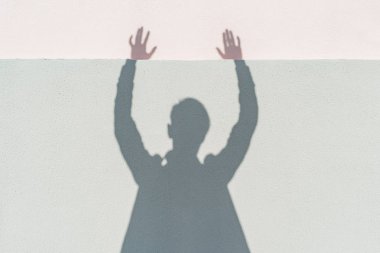 Evin duvarında gölgeler, insanoğlunun ellerinde.