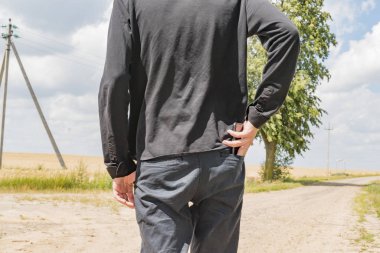 Genç adam telefonu arka cebine koyuyor.