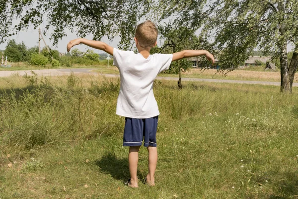 街の外に白いTシャツを着た小さな男の子がカメラをポーズをとって — ストック写真