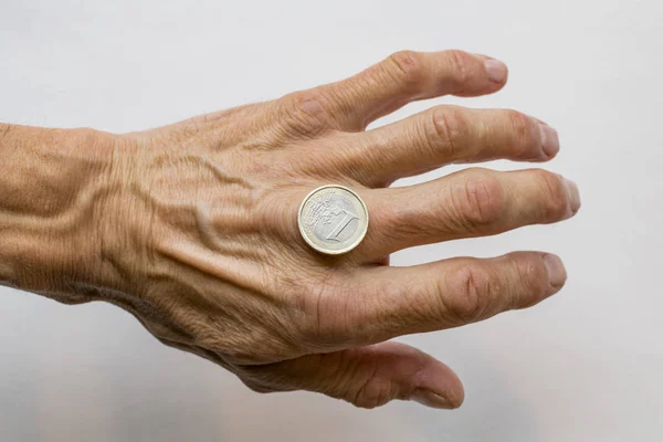 Mano del hombre sosteniendo una moneda de euro — Foto de Stock