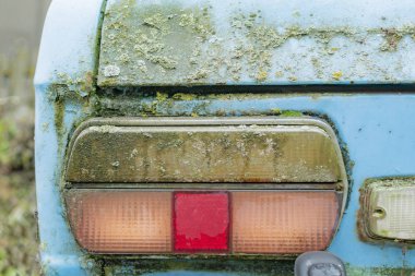 Çamurla kaplı eski bir arabanın parçası.