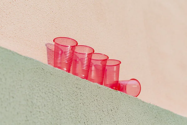 Κόκκινα πλαστικά ποτήρια είναι στον τοίχο του σπιτιού — Φωτογραφία Αρχείου