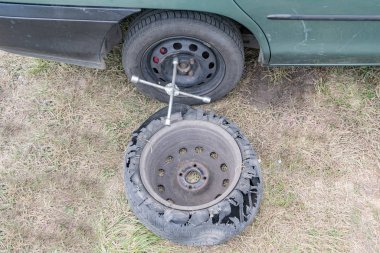 Arabanın tekerleğinin yumruklanmış lastiğinin değiştirilmesi.