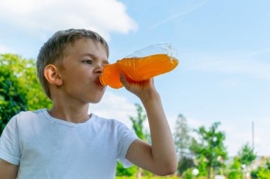 Bir şişe tatlı içeceği olan küçük çocuk.