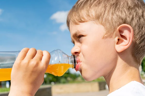 Bir şişe tatlı içeceği olan küçük çocuk.