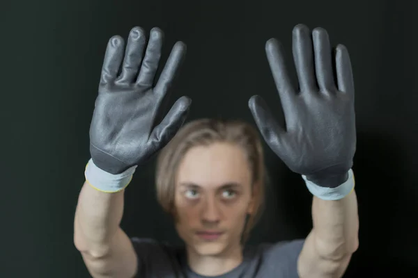 The young man holds his gloved hands — Stock Photo, Image
