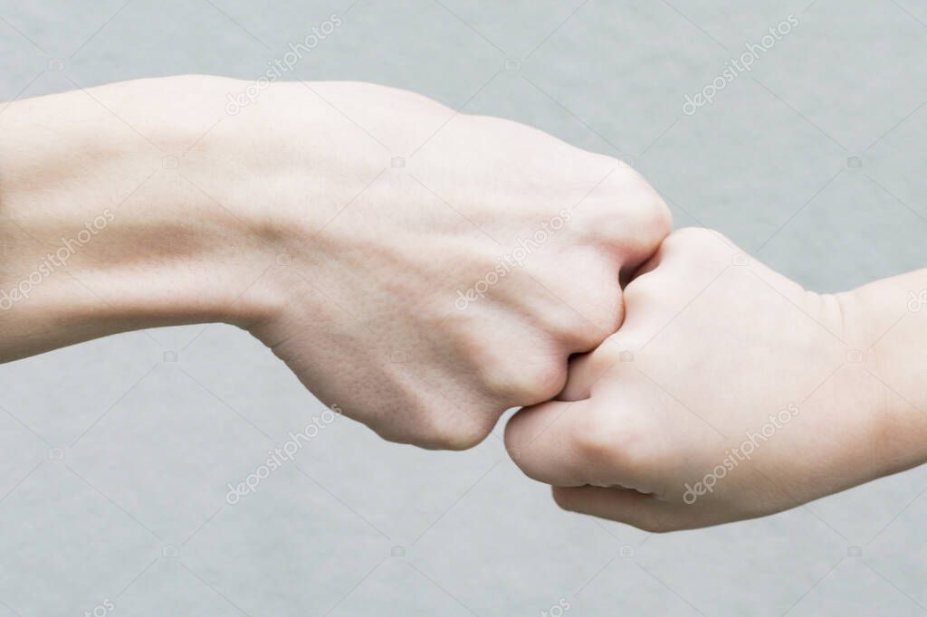 Image of the hands of an adult and a boy