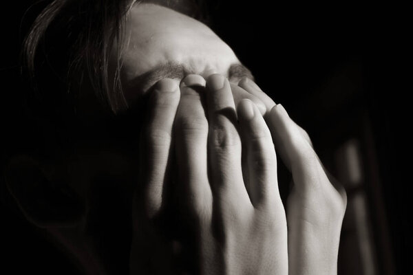 Fragment of the face of a young guy in a dark room