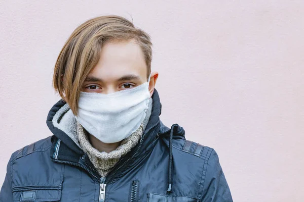 An adult guy puts a protective medical mask on his face