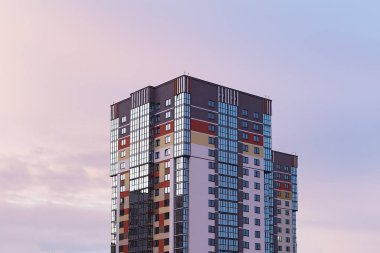 Akşam gökyüzünün arka planında çok katlı yeni bir bina