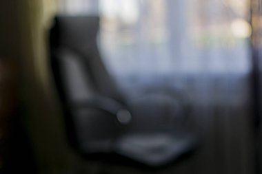 Odanın içindeki pencerenin yakınındaki bir sandalyenin bulanık görüntüsü