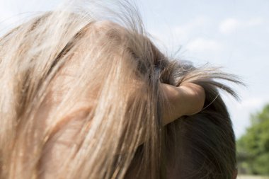 Genç adam ellerini başının üstüne koydu.