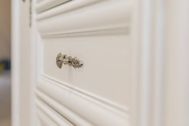 Metal saplı beyaz çekmeceli yeni bir çekmecenin parçası.