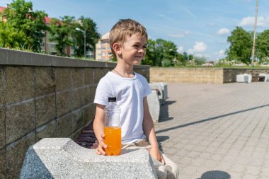 Bir şişe tatlı içeceği olan küçük çocuk.