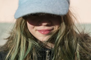 Siyah ceketli genç bir kız kameranın önünde poz veriyor.