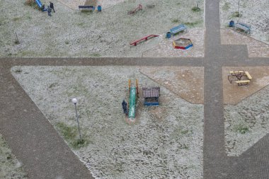 Kar yağışı sırasında boş bir oyun alanı. Tepeden manzara.