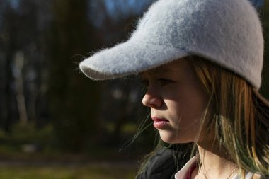 Siyah ceketli genç bir kız kameranın önünde poz veriyor.