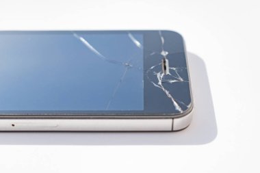 Beyaz arkaplanda kırık ekranlı telefon