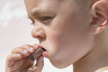 Küçük çocuk çikolata yiyor.