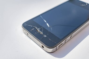 Beyaz arkaplanda kırık ekranlı telefon