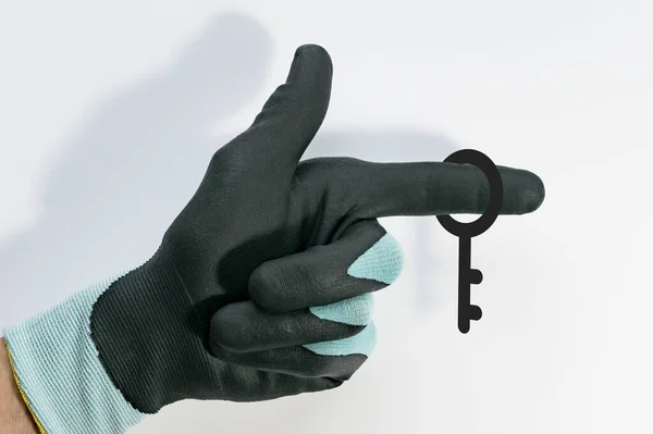 Image of a gloved hand and a lock key on a light background
