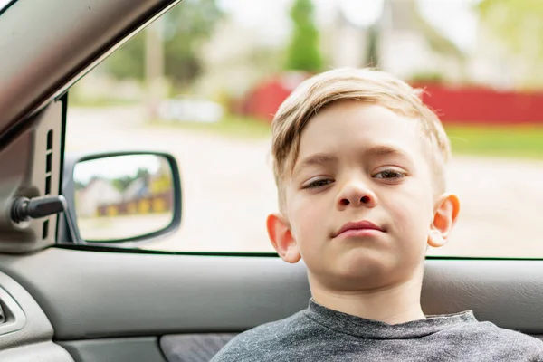 Küçük bir çocuk araba koltuğunda oturuyor.