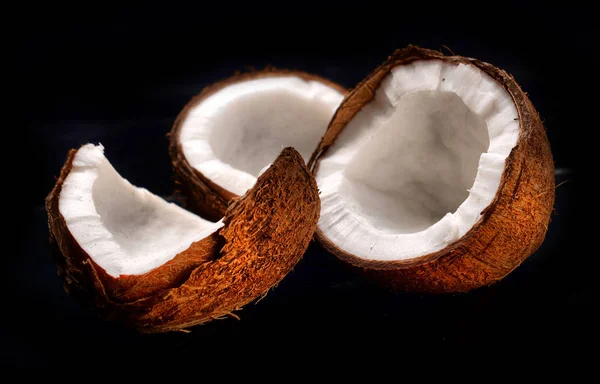 Segmentos de coco sobre fundo preto — Fotografia de Stock