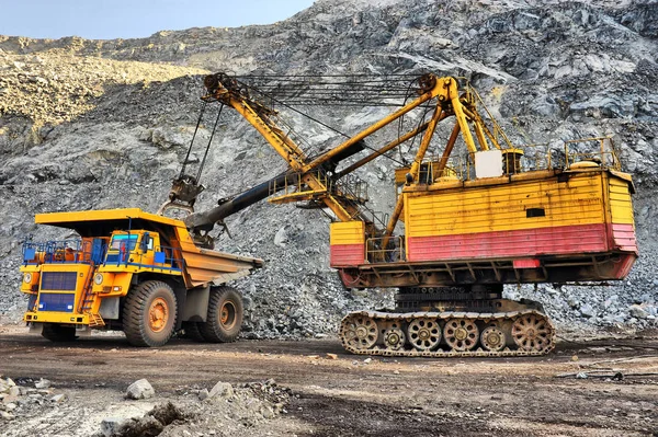 Loading of iron ore on very big dump-body truck — Stock Photo, Image