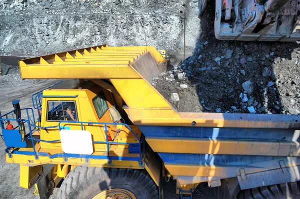 Excavadora cargando mineral de hierro en camiones volquete pesados en las opencas — Foto de Stock