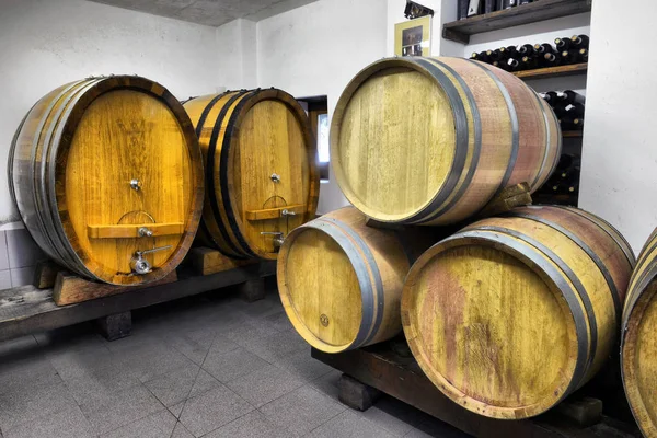 Wine barrels stacked in the old cellar of the winery. — Stock Photo, Image