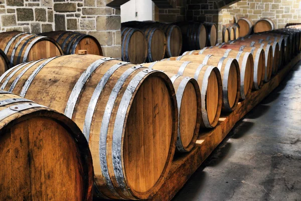 Wine barrels stacked in the old cellar of the winery. — Stock Photo, Image