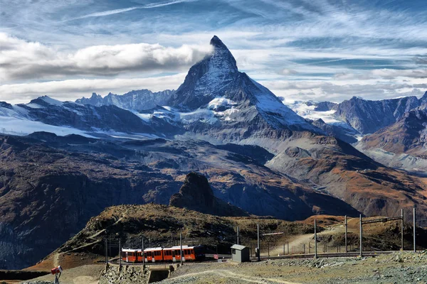 Zermatt Suiza. Famoso tren turístico rojo eléctrico que viene hacer — Foto de Stock