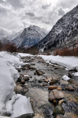 Bulutlu bir günde kışın nehir Alp dağ