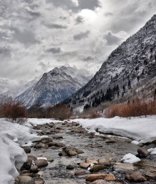 Bulutlu bir günde kışın nehir Alp dağ