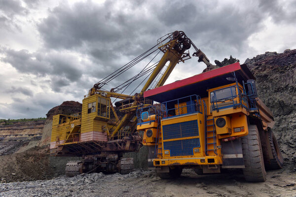 Large quarry dump truck. Loading the rock in the dumper. Loading