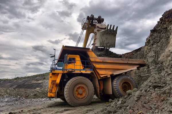 Un grande camion per la discarica di cave. Carico la roccia nel cassonetto. Caricamento in corso — Foto Stock