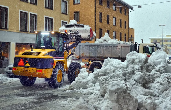 Snow cleaning tractor snow-removal machine loading pile of snow — Stock fotografie