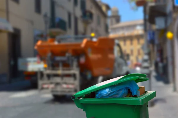 Pojemnik na śmieci na tle śmieciarki — Zdjęcie stockowe