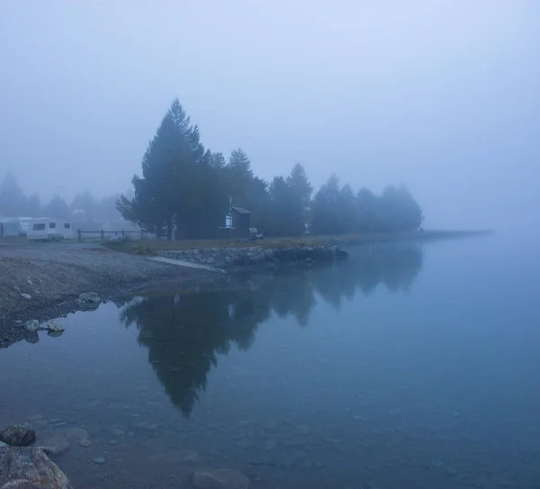 Mlha nad horským jezerem před úsvitem. — Stock fotografie